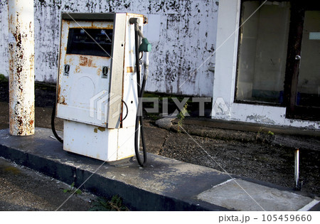 夕日を受ける廃墟のガソリンスタンド 給油機の写真素材 [105459660