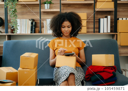 Fashion blogger concept, Young African women selling clothes on video streaming.Startup small business SME, using smartphone or tablet taking receive and checking.. Fashion blogger concept, Young African women selling clothes on video streaming.Startup small business SME, using smartphone or tablet taking receive and checking.. 105459871