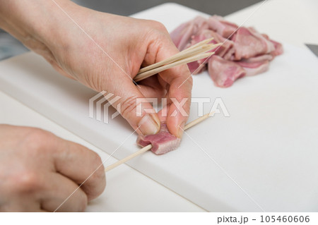 【焼き鳥豚タンの串打ちをする主婦】 105460606