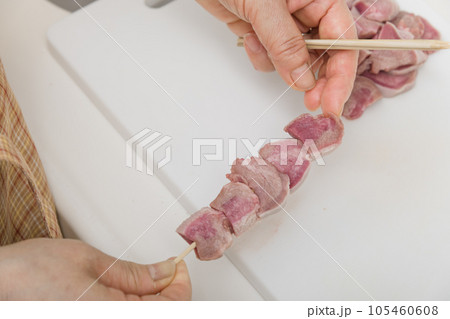 【焼き鳥豚タンの串打ちをする主婦】 105460608