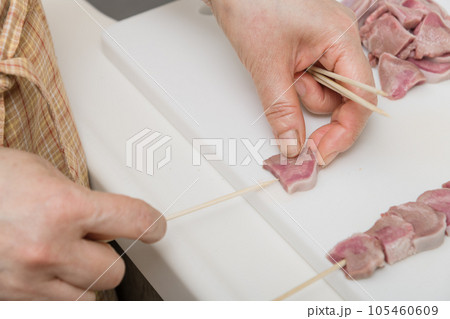 【焼き鳥豚タンの串打ちをする主婦】 105460609