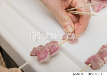 【焼き鳥豚タンの串打ちをする主婦】 105460612