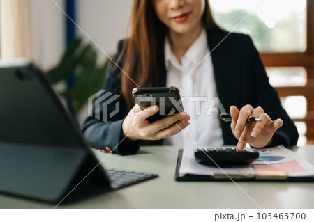 businesswoman or accountant hand typing laptop working to calculate on desk about cost at home office.. businesswoman or accountant hand typing laptop working to calculate on desk about cost at home office.. 105463700
