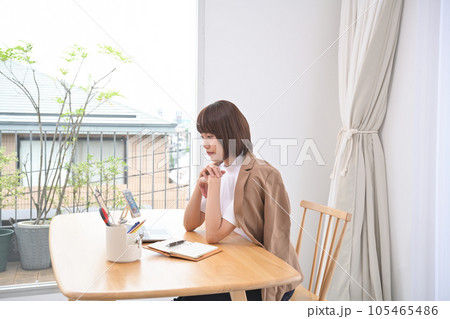屋内のテーブルでノートパソコンの操作をする女性 屋内のテーブルでノートパソコンの操作をする女性 105465486