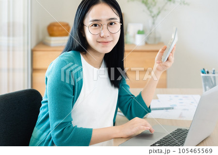 パソコンと電卓で計算する若い女性 パソコンと電卓で計算する若い女性 105465569