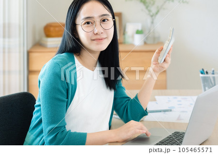 パソコンと電卓で計算する若い女性 パソコンと電卓で計算する若い女性 105465571
