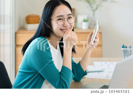パソコンと電卓で計算する若い女性 パソコンと電卓で計算する若い女性 105465581