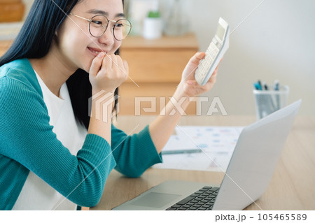 パソコンと電卓で計算する若い女性 パソコンと電卓で計算する若い女性 105465589