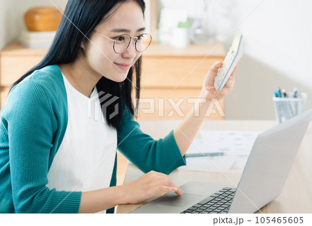 パソコンと電卓で計算する若い女性 パソコンと電卓で計算する若い女性 105465605