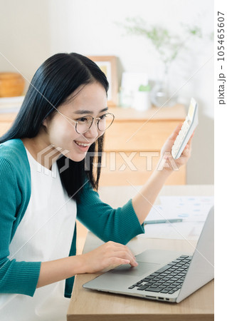 パソコンと電卓で計算する若い女性 105465607