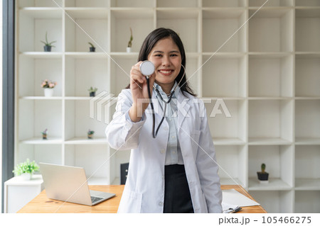 Portrait of asian female doctor smiling while using stethoscope 105466275