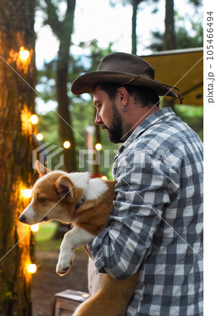 Happy bearded man holding his welsh corgi dog  105466494