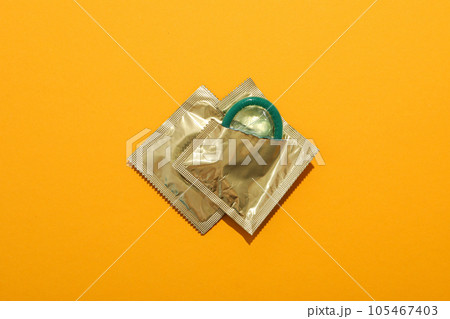 Green condoms on a yellow background close-up Green condoms on a yellow background close-up 105467403