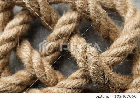 Thick knotted rope close-up on gray background Thick knotted rope close-up on gray background 105467606