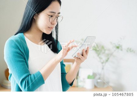 電卓で計算する若い女性 電卓で計算する若い女性 105467805