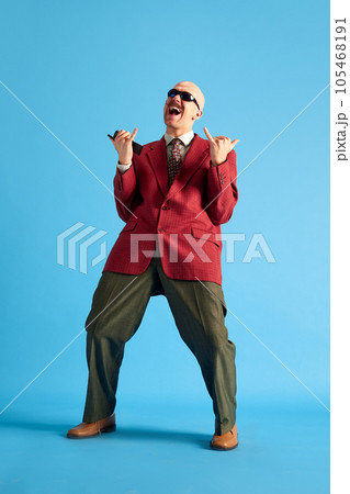 Full lenght image. Balded man with mustache dressed vintage dansing with call-sign and shouting over blue background. 105468191