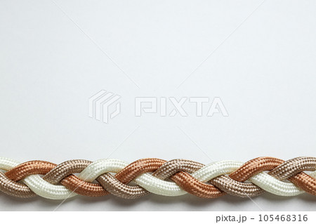 Braided multicolored ropes on a white background. Concept of unity. Place for text Braided multicolored ropes on a white background. Concept of unity. Place for text 105468316
