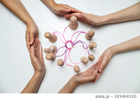 A round knot of threads unites the wooden figures A round knot of threads unites the wooden figures 105468320