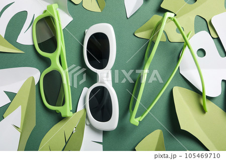 Glasses on a green background with paper tropical leaves 105469710