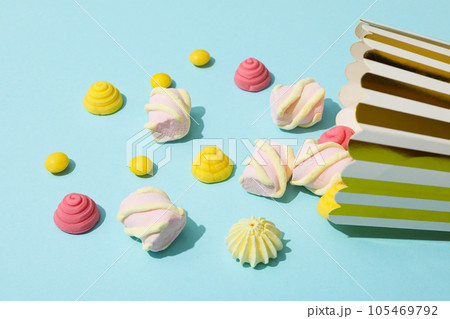 Jelly candies and marshmallows, popcorn bag on blue background 105469792