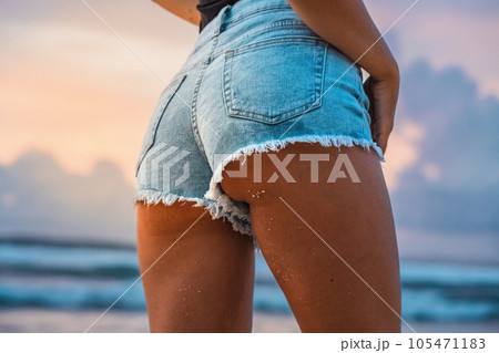 Close up photo of beautiful girl's buttocks wearing jeans at sunset 105471183
