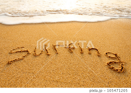The word surfing written in the sand on the beach The word surfing written in the sand on the beach 105471205