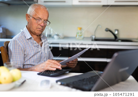 Senior man counting with calculator 105471291