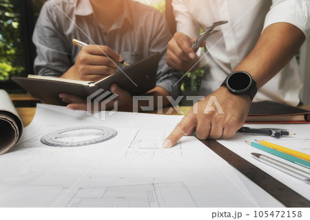 Confident team of architect working together in a office.They discussing about new startup project on desk. Architect discuss with engineer about project in office, architectural concept 105472158