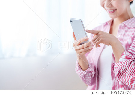 スマートフォンを操作する女性（パーツモデル） 105473270