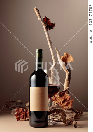 Bottle and glass of red wine with a composition of old wood. Bottle and glass of red wine with a composition of old wood. 105473782