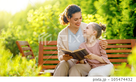 girl and her mother reading a book 105474432