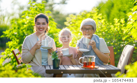 family drinking tea in the garden family drinking tea in the garden 105474493