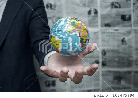 Earth planet in male hand on newspaper background. Businessman holding Earth Earth planet in male hand on newspaper background. Businessman holding Earth 105475394