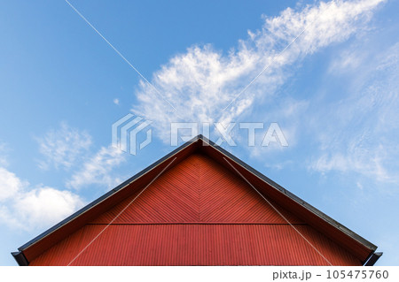 Red wooden gable is under blue cloudy sky on a daytime 105475760