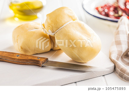 Smoked scamorza cheese on cutting board. 105475893