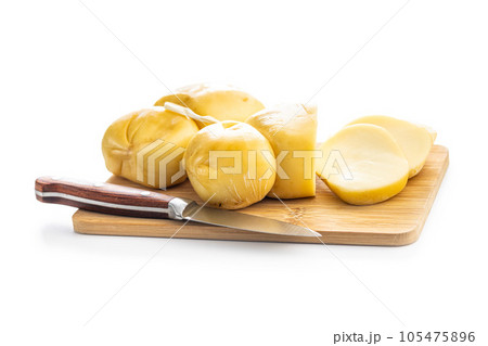 Smoked scamorza cheese on cutting board isolated on white background. 105475896