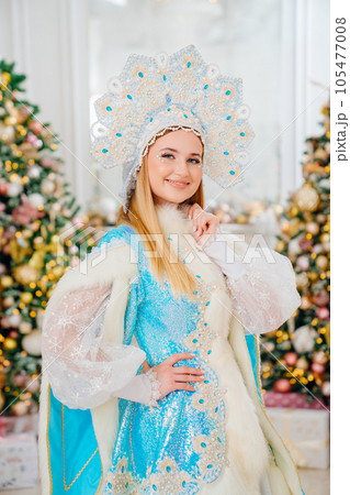 portrait of Snow Maiden in blue costume with kokoshnik. room with christmas tree portrait of Snow Maiden in blue costume with kokoshnik. room with christmas tree 105477008