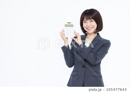 白い背景の前で電卓を持つ30代の働く女性 白い背景の前で電卓を持つ30代の働く女性 105477643