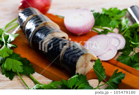 Mild-cured scomber with parsley and onion on wooden surface Mild-cured scomber with parsley and onion on wooden surface 105479180