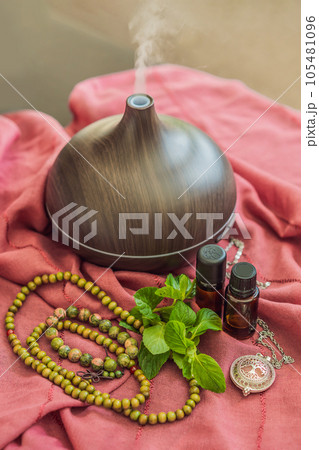 A captivating photo capturing the essence of relaxation and ambiance with an aroma oil and aroma diffuser, creating a soothing and serene atmosphere A captivating photo capturing the essence of relaxation and ambiance with an aroma oil and aroma diffuser, creating a soothing and serene atmosphere 105481096