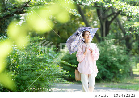 日傘を刺して歩くシニアの女性 105482323