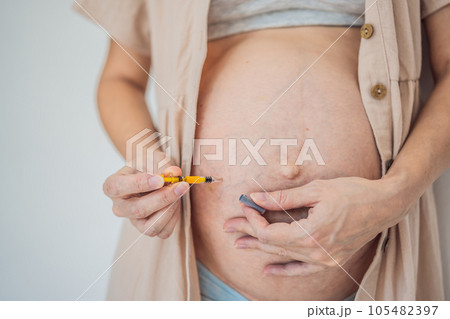 Woman injects a dose of heparin into her belly 105482397