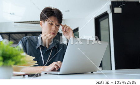 Tired stressed office worker sitting at desk and thinking, he is rubbing his eyes and feeling exhausted Tired stressed office worker sitting at desk and thinking, he is rubbing his eyes and feeling exhausted 105482888