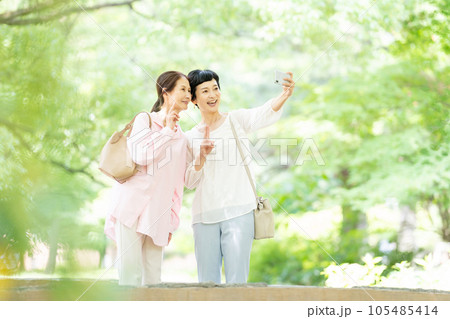スマホで記念写真を撮るミドルの女性 スマホで記念写真を撮るミドルの女性 105485414