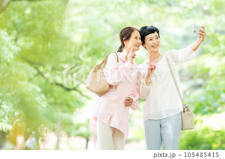 スマホで記念写真を撮るミドルの女性 スマホで記念写真を撮るミドルの女性 105485415