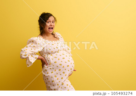 Stupefied pregnant woman holding belly, crying and shouting looking at camera. Easy delivery, pregnancy and parturition Stupefied pregnant woman holding belly, crying and shouting looking at camera. Easy delivery, pregnancy and parturition 105493274