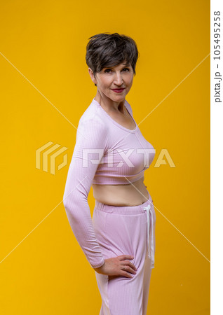 Short-haired senior smiling woman in pink Short-haired senior smiling woman in pink 105495258