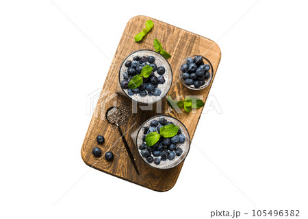 Healthy breakfast or morning with chia seeds vanilla pudding and blueberry berries on table background, vegetarian food, diet and health concept. Chia pudding with coconut milk and blueberry 105496382