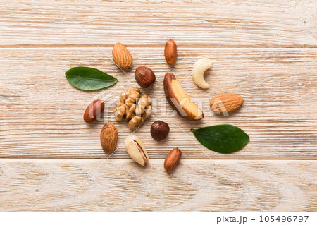 Composition of nuts , flat lay - mix hazelnuts, cashews, almonds on table background. healthy eating concepts and food background Composition of nuts , flat lay - mix hazelnuts, cashews, almonds on table background. healthy eating concepts and food background 105496797