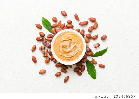Bowl of peanut butter and peanuts on table background. top view with copy space. Creamy peanut pasta in small bowl 105496857